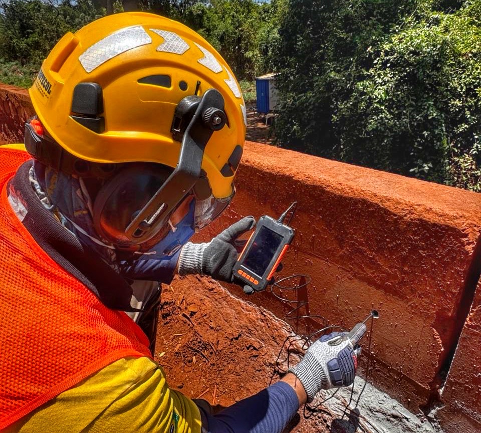 Profissional inspecionando estrutura com equipamento de detecção