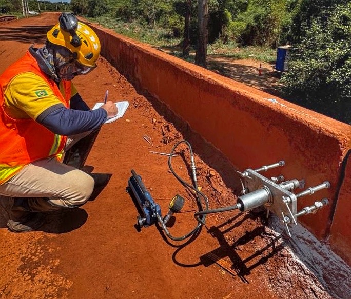 Profissional registrando dados durante teste de ancoragem em campo